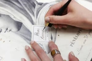 ビュリーのカリグラフィーサービス、スタッフがペンを使って商品ラベルに美しい手書き文字を書き入れている様子